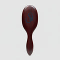 Top view of 7th Heaven hair extensions brush featuring engraved logo on luxury wooden handle