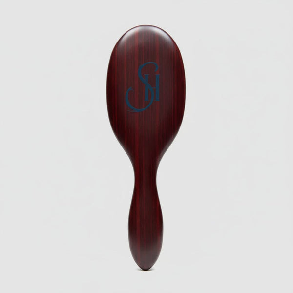 Top view of 7th Heaven hair extensions brush featuring engraved logo on luxury wooden handle