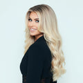 Three quarter view of 16 inch Divine Pearl Blonde clip in hair extensions styled with soft waves and luminous shine