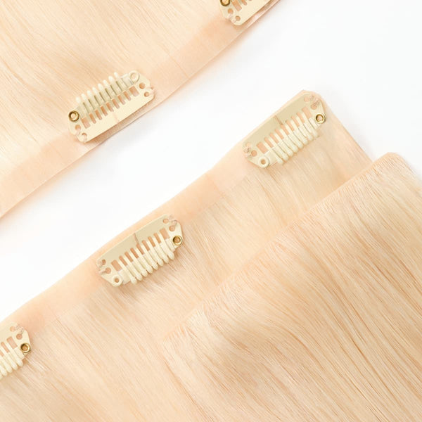 Close-up of seamless band on luminescent light golden blonde clip-in hair extensions