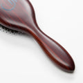 Close-up of luxury wooden handle on 7th Heaven hair extensions brush designed for professional use