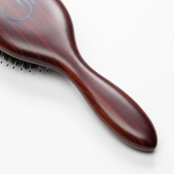 Close-up of luxury wooden handle on 7th Heaven hair extensions brush designed for professional use