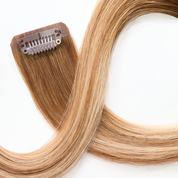 Close-up of secure clip attachment on rooted dark sandy bronde clip-in hair extensions
