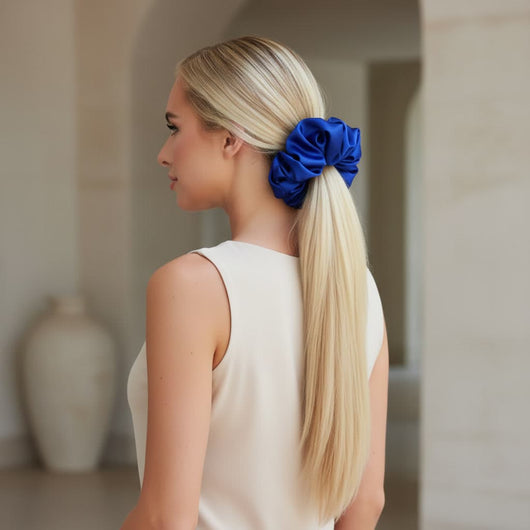 Woman wearing oversized blue mulberry silk scrunchie in low ponytail for elegant everyday style