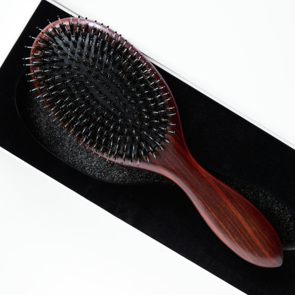 Model using the Sublime Sandalwood Extension Brush to detangle and style Decadent Chocolate Brown hair extensions from Seventh Heaven.