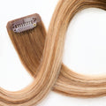 Close-up of secure clip attachment on rooted dark sandy bronde clip-in hair extensions