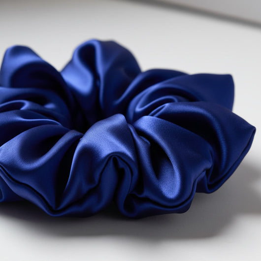 Close-up of oversized blue mulberry silk scrunchie showing smooth silk texture and sculptural folds
