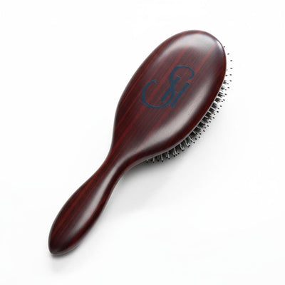 Angled view of 7th Heaven hair extensions brush showing wooden handle and professional bristle design